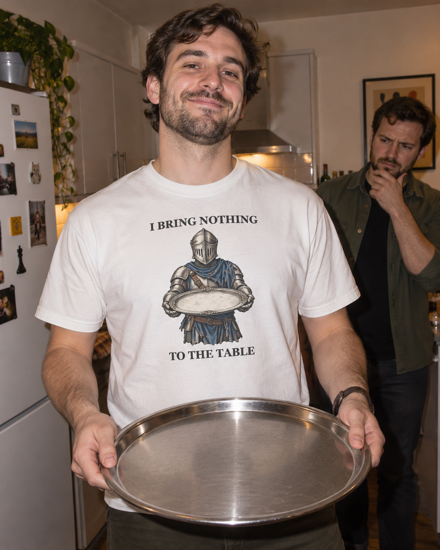 Illustrative mockup of a man wearing the I Bring Nothing to the Table tee and holding an empty tray in a kitchen.